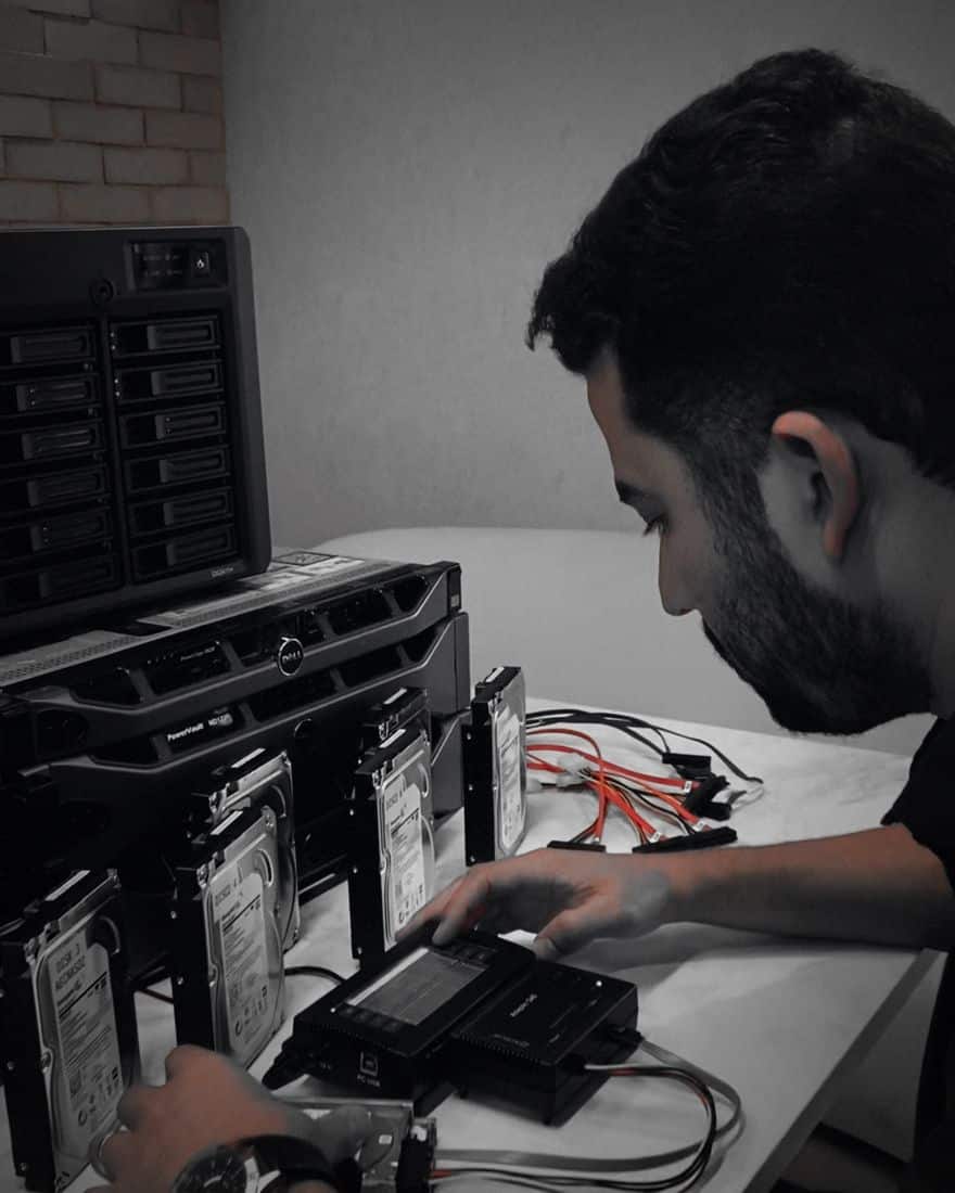 Recuperação de dados de servidores 17 Especialista da UTI dos Dados copiando discos de servidor com PC-3000 na bancada do laboratório